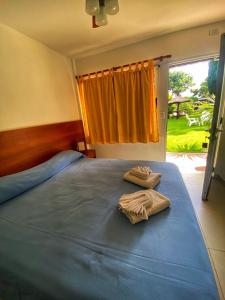 ein Schlafzimmer mit einem Bett mit zwei Handtüchern darauf in der Unterkunft Hotel El Faro in Villa Gesell