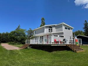 a large white house with a porch and stairs at Oyster Shell Cottage in York