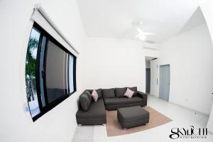 ein Wohnzimmer mit einem Sofa und einem Fenster in der Unterkunft Skylight Suites Hotel in San Felipe de Puerto Plata