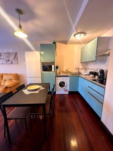 a kitchen and living room with a table and a dining room at El rincón acogedor in Medina de Pomar