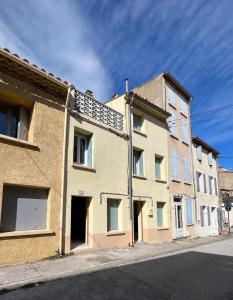 um edifício de apartamentos ao lado de uma rua em Maison Emile - Coeur du village - 8 personnes - Clim - Superbe literie em Leucate