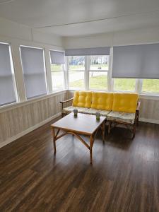 Sala de estar con sofá amarillo y mesa de centro en Spring into spring at Spring Lake!, en Spring Lake