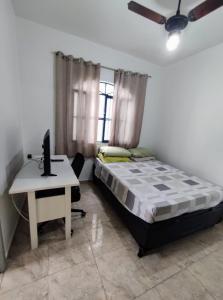 a bedroom with a bed and a desk with a computer at Casa da cama elástica - Alto da Boa vista - 3 quartos in Araruama +50 photos