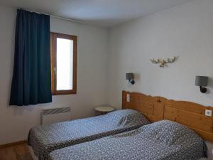 um quarto com uma cama e uma janela em Horizon Pelvoux Accueillant T2 pied des pistes em Puy-Saint-Vincent