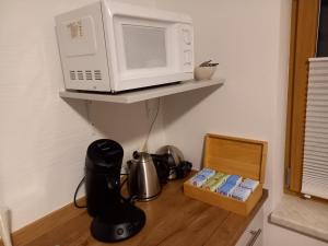 a microwave sitting on a shelf next to a table at Lovely Rita in Kaprun