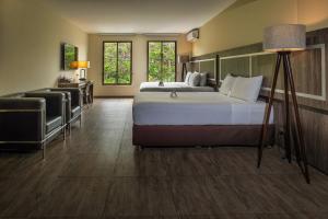 een slaapkamer met een bed, een bureau en een stoel bij Rado Hotel - Quintanas in Trujillo