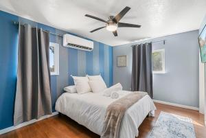 - une chambre avec des murs bleus et un lit avec un ventilateur de plafond dans l'établissement Casita Rio, à Albuquerque
