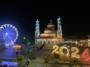 a large building with a ferris wheel in front of it at Lovely flat in the heart of Korca #1 in Korçë