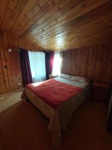 sypialnia z łóżkiem w drewnianym pokoju w obiekcie Grandes cabañas w mieście Pucón