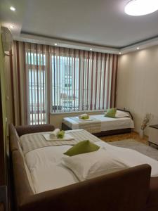 a bedroom with two beds and a large window at Guest House Dani in Pomorie