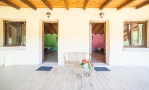 a porch with a table and chairs and windows at Sa Tanchitta in Ul&agrave; Tirso