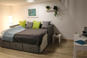 een slaapkamer met een bed met groene en grijze kussens bij Nefelejcs apartman (Netflix) in Boedapest