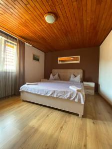 a bedroom with a large bed with a wooden ceiling at Casa Nicolae in Silvaşu de Sus