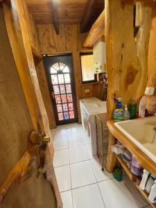 a kitchen with a sink and a door in a room at Hostal El Durmiente a 5 minutos del centro de Panguipulli in Panguipulli
