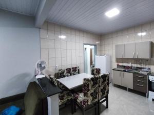 uma cozinha com uma mesa e cadeiras e um frigorífico em Casa nas termas de Piratuba em Piratuba