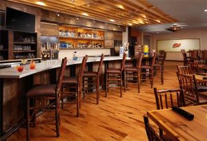 a bar in a restaurant with wooden floors and chairs at Great Wolf Lodge New England in Leominster