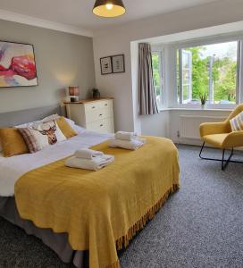 um quarto com uma cama grande e toalhas em Meadow View em Stamford