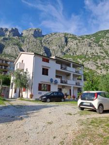 un edificio con dos coches estacionados frente a él en Apartments Nadja en Kotor