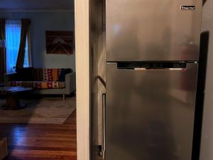 a stainless steel refrigerator in a living room with a couch at Seafare in Seaside