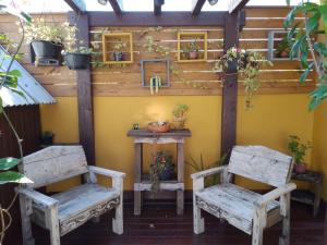 duas cadeiras sentadas em frente a uma parede com plantas em Casa de férias temporada em Xangri-lá