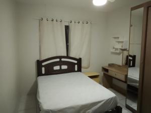 1 dormitorio con cama, tocador y espejo en Casa de férias temporada, en Xangri-lá