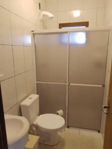 uma casa de banho com um WC e uma cabina de duche. em Casa de férias temporada em Xangri-lá