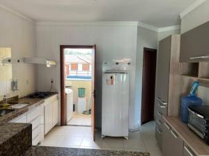a kitchen with a refrigerator in the middle of it at Apartamento mobiliado in Porto Seguro