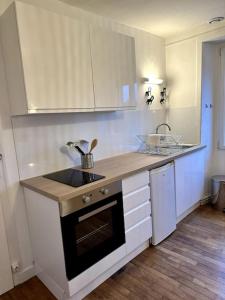 uma cozinha com armários brancos e uma bancada em Appartement rénové entre Saint-Malo et le Mont-Saint-Michel em Dol-de-Bretagne