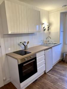 a kitchen with white cabinets and a counter top at Appartement rénové entre Saint-Malo et le Mont-Saint-Michel in Dol-de-Bretagne