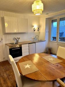uma cozinha com uma mesa de madeira e uma cozinha com uma mesa e cadeiras em Appartement rénové entre Saint-Malo et le Mont-Saint-Michel em Dol-de-Bretagne
