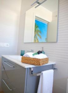 a bathroom with a sink with a basket on it at Suites Verano Azul in Castillo del Romeral