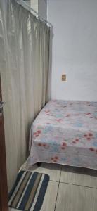 1 dormitorio con 1 cama con cortina y alfombra en Descanse e aconchego, en Itajaí