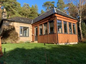 a house with a lot of windows in a yard at Amazing cottage with private indoor swim pool and hot tub in Grantown on Spey