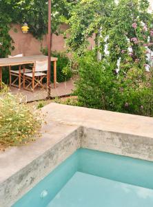 una piscina en un jardín con mesa y árboles en Ses Sucreres Small & Slow Hotel, en Ferreries