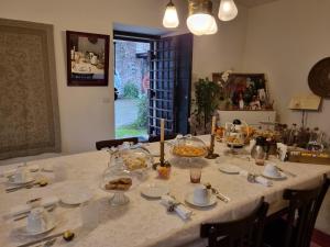 una mesa con un mantel blanco con comida. en Casa Zia Cianetta Residenza di Campagna, en Capodacqua di Foligno