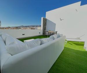 sala de estar con muebles blancos y césped verde en Suites Verano Azul, en Castillo del Romeral