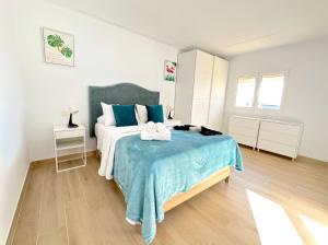 ein Schlafzimmer mit einem Bett mit einer blauen Decke in der Unterkunft Suites Verano Azul in Castillo del Romeral