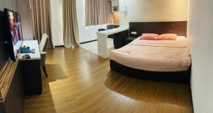 a bedroom with a bed with two pink pillows on it at Staycity@KBCP in Kota Bharu