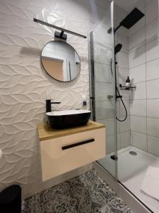 uma casa de banho com um lavatório e um espelho em URBAN APARTMENTS PREMIUM No12 Chorzów, Katowice with PRIVATE PARKING em Chorzów