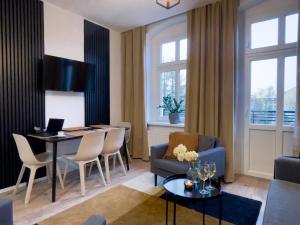 a living room with a table and chairs and a couch at URBAN APARTMENTS PREMIUM No12, Free Parking, Self Check-in in Chorzów