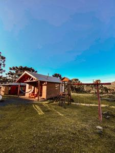 a small house with a fence and a playground at Casa de Campo Santa Paulina in Urupema