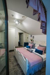 a bedroom with a large bed with blue and pink pillows at Modra Sikorka in Smardzewice