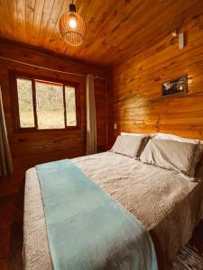 sypialnia z łóżkiem w drewnianym domku w obiekcie Casa de Campo Santa Paulina w mieście Urupema