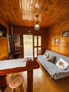 a living room with a couch and a table at Casa de Campo Santa Paulina in Urupema