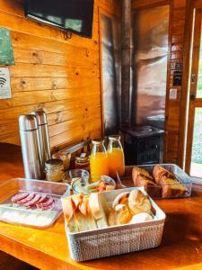 a table with a tray of bread and orange juice at Casa de Campo Santa Paulina in Urupema
