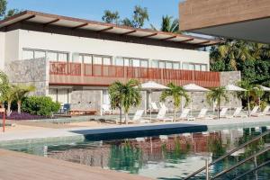 Una piscina con sillas y un edificio. en Flat Ile de Pipa Premium Positano by QAVI, en Pipa