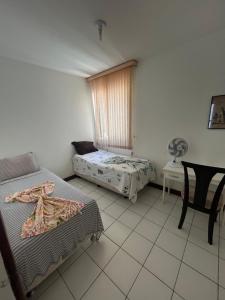 Pokój z 2 łóżkami, oknem i krzesłem w obiekcie Apartamento 5min da praia no Rio Vermelho w mieście Salvador