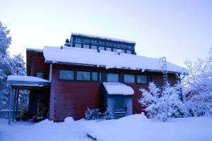 una casa roja con nieve encima en Lux Villas by Arctic People, en Rovaniemi