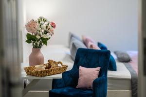 niebieskie krzesło i stół z wazonem kwiatów w obiekcie Modra Sikorka w Tomaszowie Mazowieckim