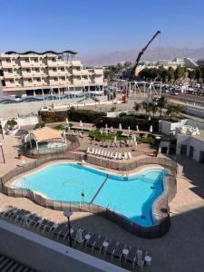 una grande piscina con sedie e un edificio di סויטה מול הים סיסייד a Eilat